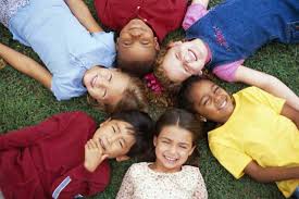 Kids laying on grass together.