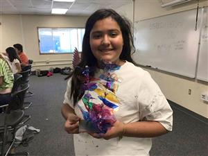 Student displaying her glass sculpture 