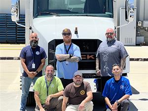 6 Cajon Valley Logistics employees in front of an EV truck